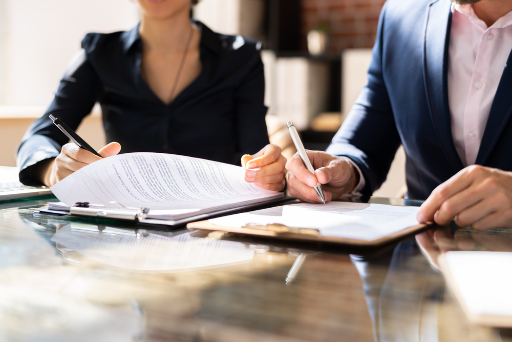 Two product liability lawyers work together to fill out legal paperwork